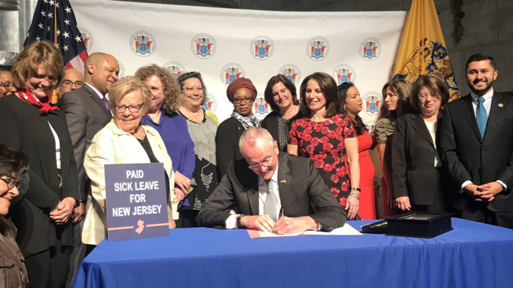 At earned sick leave bill signing, some worry over budget battle