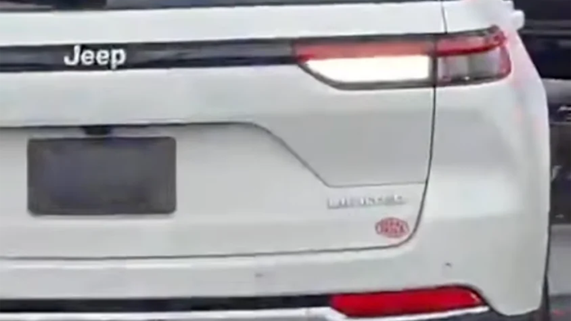 Close-up of the rear of a white Jeep Grand Cherokee, with its Jeep and Limited badges visible.